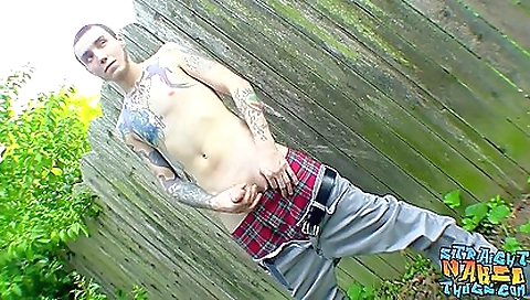 Tattooed dude in a grey hoodie masturbates in the park